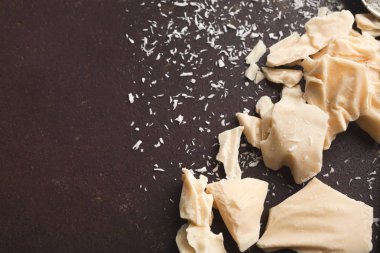 Ezilmiş beyaz çikolata parçaları ve gri arka plan üzerine Hindistan cevizi pul