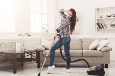 Mutlu kadın eve elektrikli süpürge ile temizlik