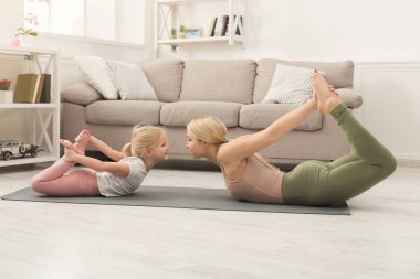 Anne ve küçük kızı birlikte yoga yaparken