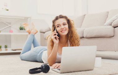 Dizüstü bilgisayar kullanarak ve cep telefonunuza konuşan öğrenci kız