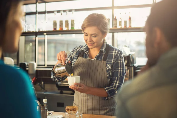 Ervaren lachende barista koffie maken aan klanten — Stockfoto