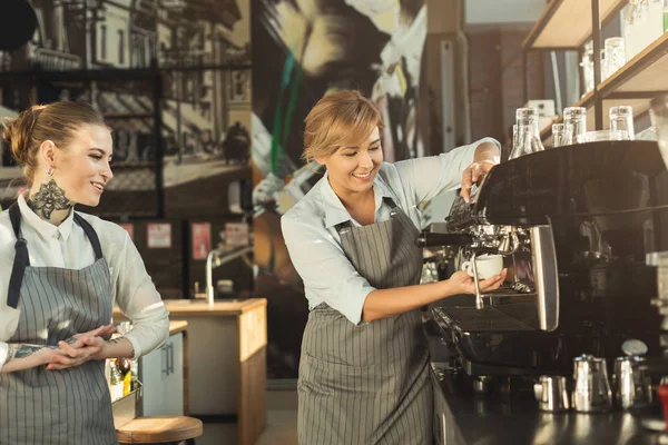 Experienced barista making coffee in professional coffee machine