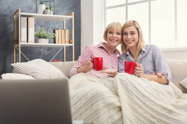Glada vuxna mor och dotter titta på film hemma. — Stockfoto