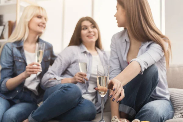 Three young female friends drinking champagne