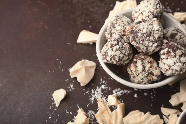 Gemalen witte chocoladestukjes en truffels op grijze achtergrond — Stockfoto