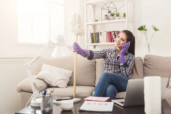 Jonge meid op telefoon te praten tijdens het reinigen — Stockfoto