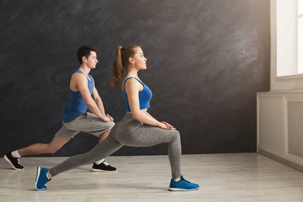 Fitnesspaar wärmt Stretchtraining drinnen auf — Stockfoto