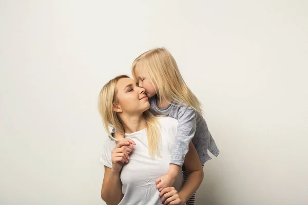 Gelukkig moeder en dochter omarmen in studio — Stockfoto