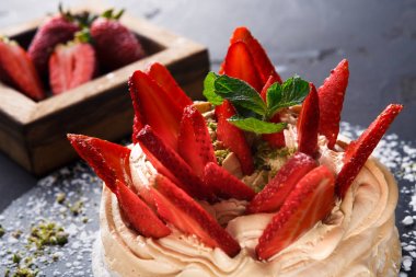 Siyah arka plan üzerine çilek ile lezzetli Anna Pavlova beze pasta