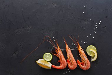 Siyah arka plan üzerine limon ve tuz ile karides