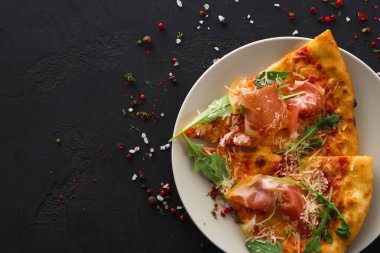 Dilimlenmiş pizza jambon ve roket salata ile