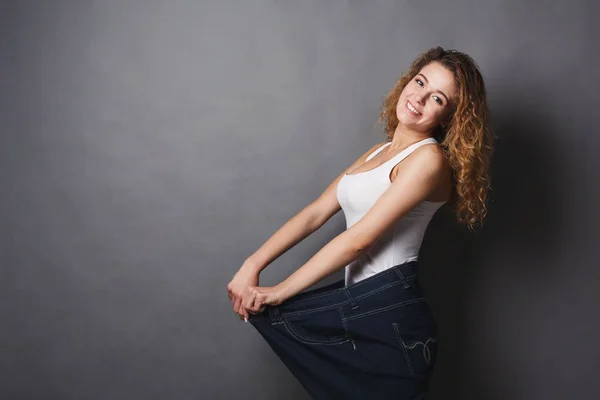 Mujer usando jeans tamaño mucho más grande — Foto de Stock