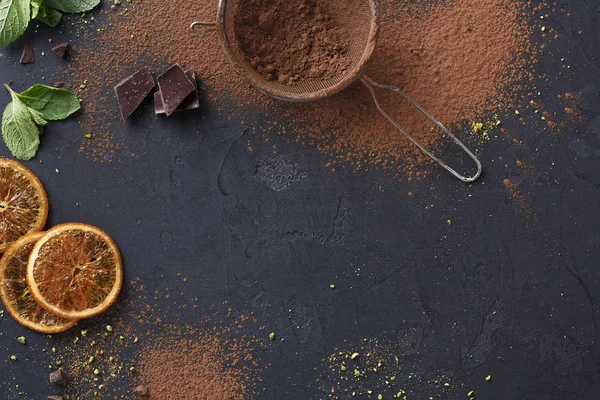 Polvo de cacao tamizado en un tamiz sobre fondo negro —  Fotos de Stock