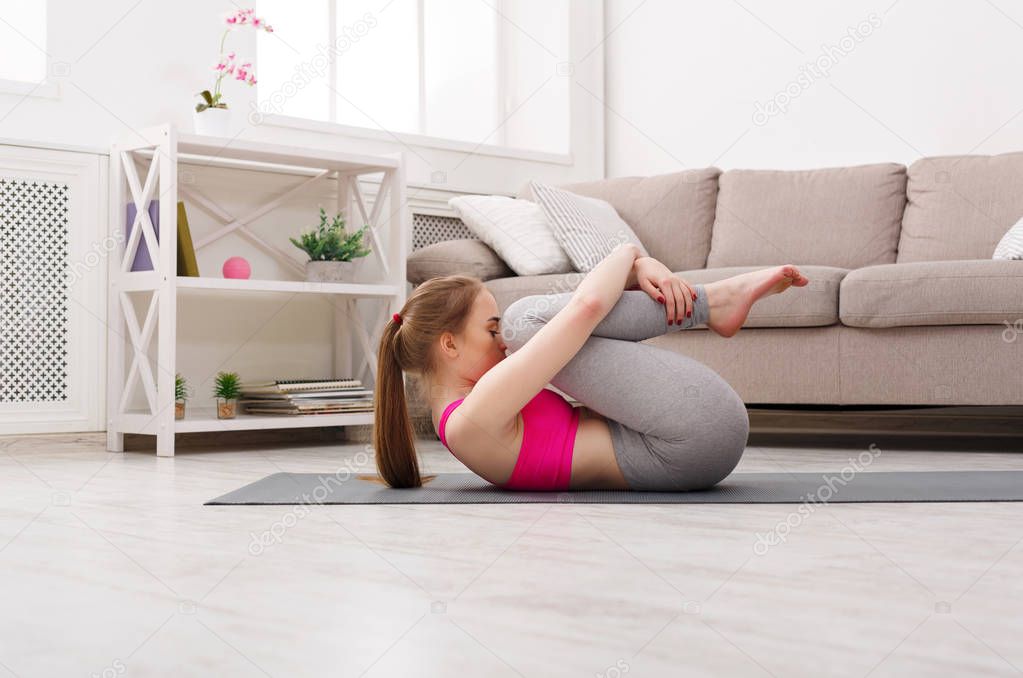 Woman training yoga in wind-relieving pose