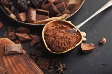 Kakao kase ve gri arka plan üzerinde ezilmiş çikolata parçaları