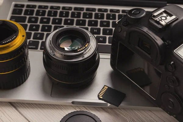 Lentes de cámara fotográfica y tarjeta de memoria en el ordenador — Foto de Stock