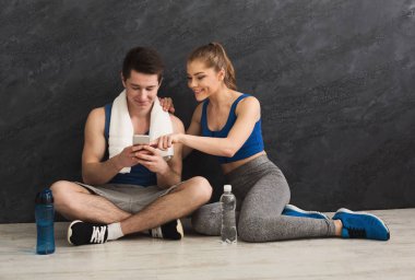 Young couple discussing workout plan at gym clipart