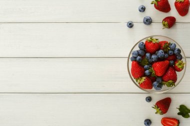 Karışık meyveli cam kase Beyaz ahşap masa üstü görünümü