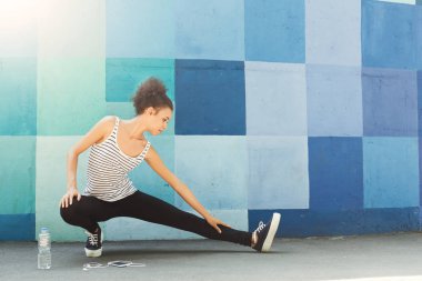 Genç bayan koşucu koşmadan önce ısınıyor.