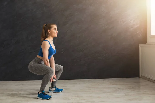 Junge schöne Frau in Sportbekleidung beim Kniebeugen — Stockfoto