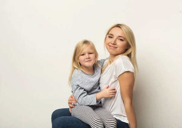 Šťastný matka a dcera objímat ve studiu — Stock fotografie