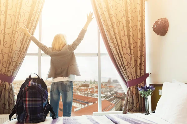 Mujer de pie cerca de la ventana en la habitación del hotel —  Fotos de Stock