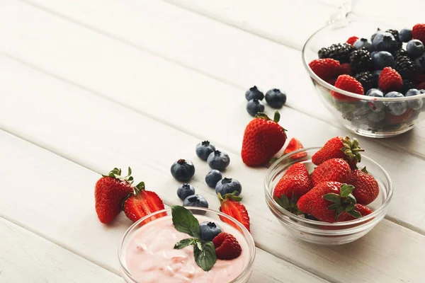 Hälsosam frukost med bär och yoghurt på vitt trä bord — Stockfoto