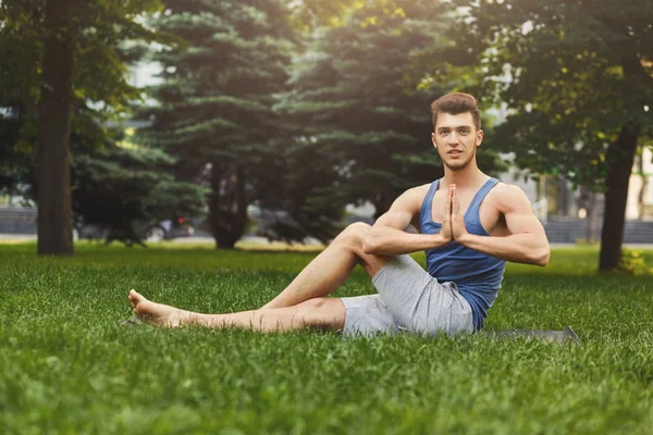 Jeune homme pratiquant le yogaoutdoors — Photo