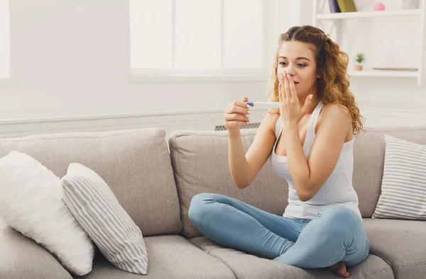 Surprised girl reading results of pregnancy test — Stock Photo, Image