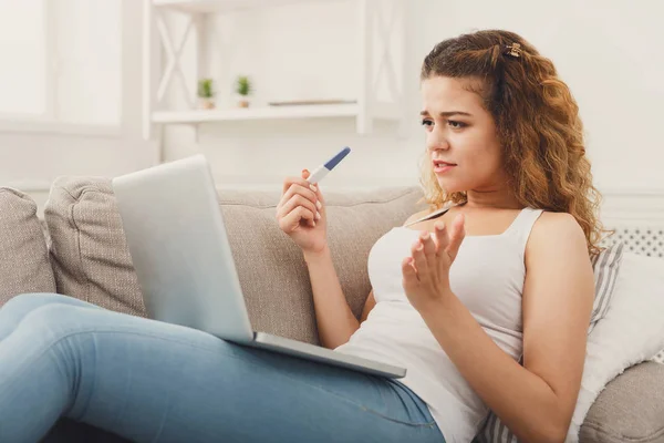 Kadın hamilelik testi ile laptop tarama — Stok fotoğraf