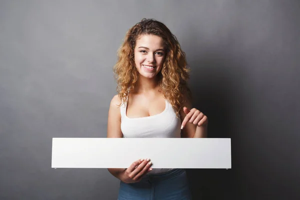 Mujer joven sosteniendo banner blanco en blanco — Foto de Stock