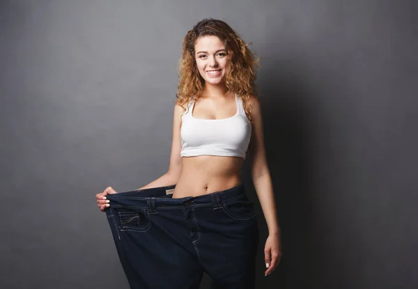 Žena nosí džíny mnohem větší velikost — Stock fotografie