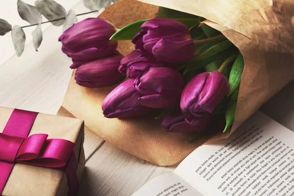 Букет фиолетовых тюльпанов и подарочная коробка на деревянном фоне — стоковое фото
