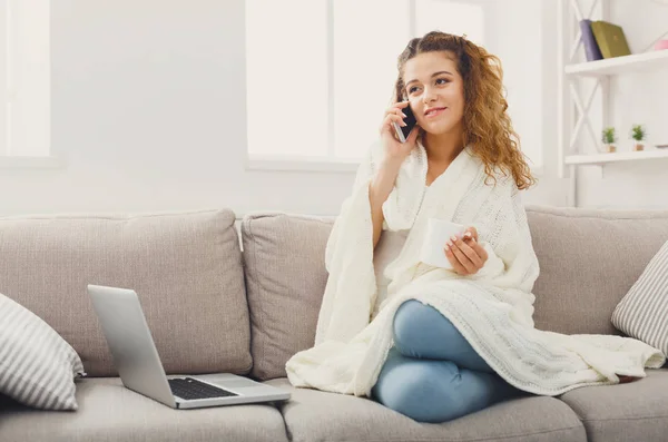 Uma casa acolhedora. Menina em cobertor com celular — Fotografia de Stock