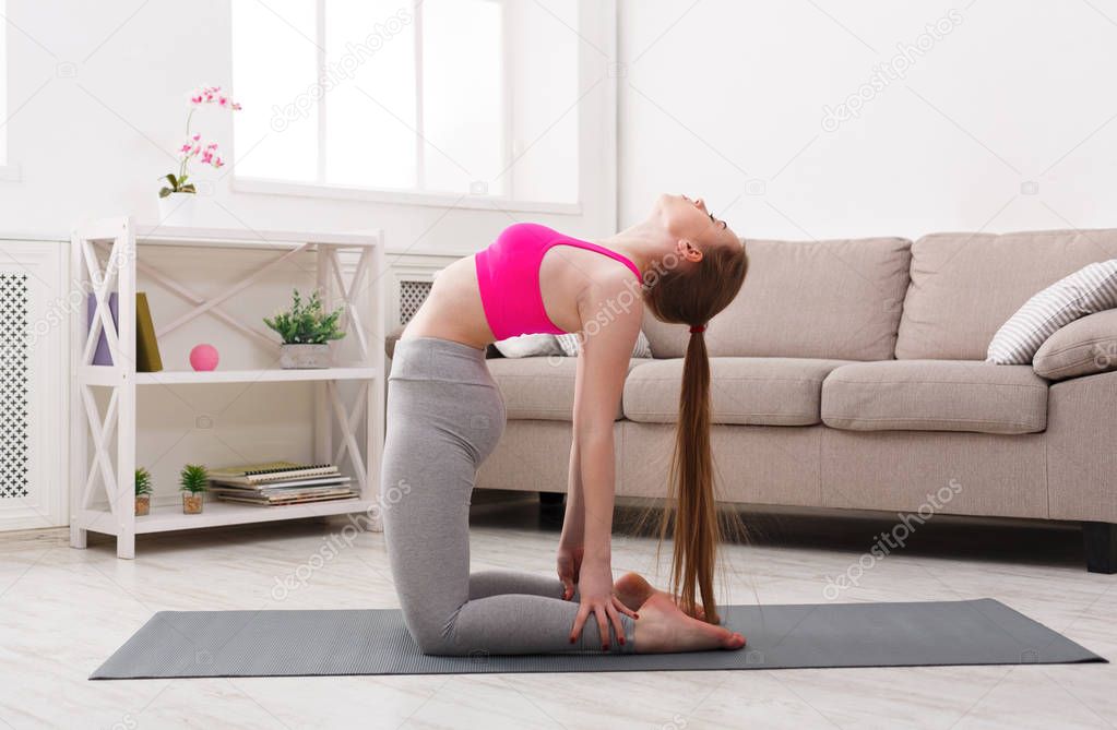 Woman training yoga in camel pose.