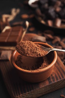 Kakao kase ve gri arka plan üzerinde ezilmiş çikolata parçaları
