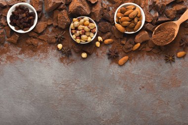 Ezilmiş çikolata parçaları ve kakao gri arka planda, üstten görünüm