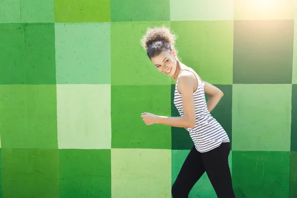 Side view of woman running against bright wall — Stock Photo, Image