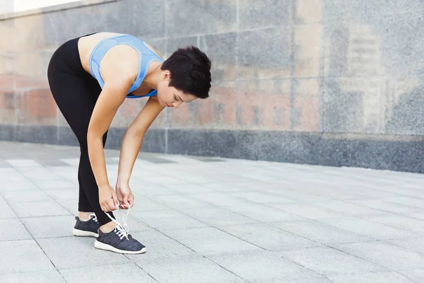 Mujer atando cordones zapatos antes de correr — Foto de Stock