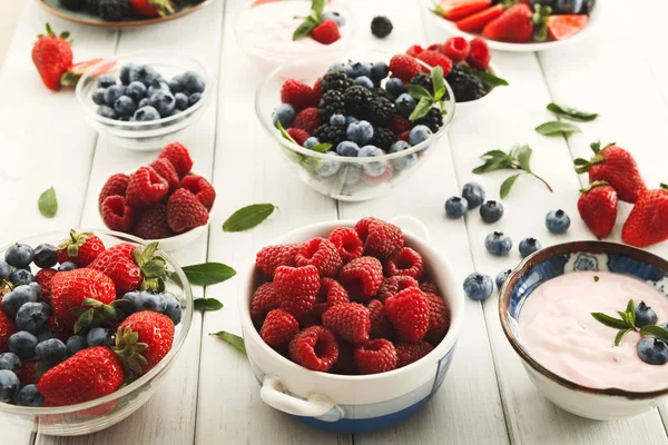 Hälsosam frukost med bär och yoghurt på vitt trä bord — Stockfoto