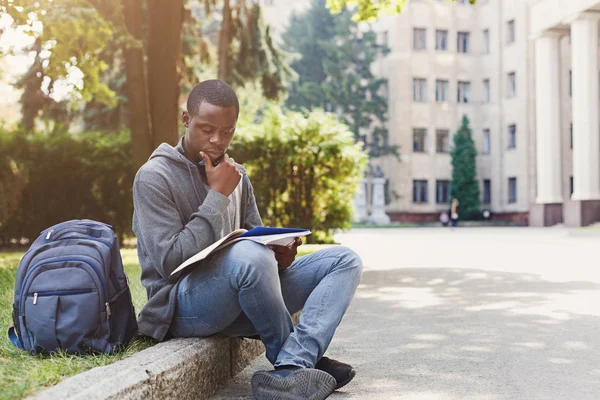 Jeune homme lisant des notes à l'espace de copie universitaire — Photo