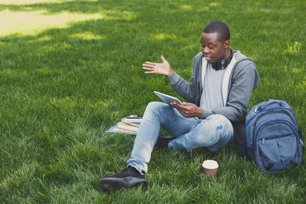 Wanhopige jonge man met behulp van de tablet buitenshuis — Stockfoto