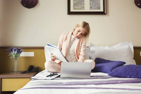 Empresária sentada na cama e usando laptop — Fotografia de Stock