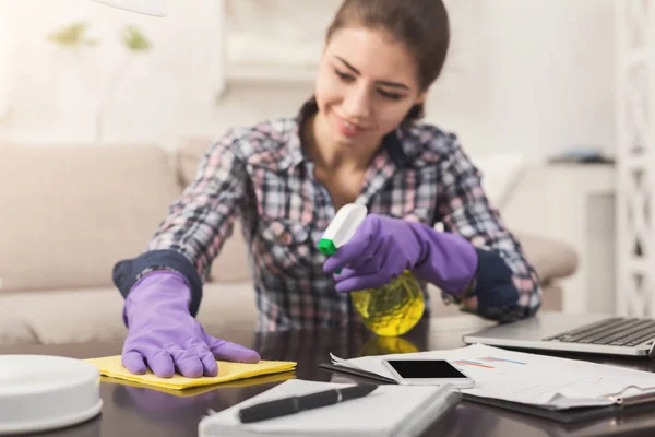 Vrouw met behulp van Spray schoner op houten oppervlak — Stockfoto