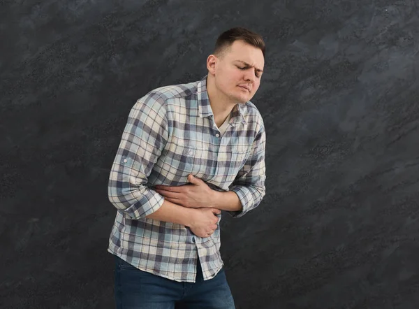 Frustrato bello giovane uomo con mal di stomaco — Foto Stock