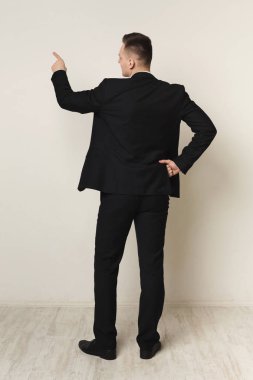 İşadamı boş duvara geri görünüm yazma