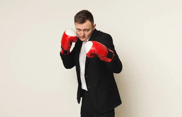 Empresário em luva de boxe vermelho soco para o objetivo — Fotografia de Stock