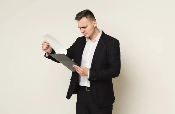Ernster Mann mit Notizblock auf weißem Hintergrund — Stockfoto