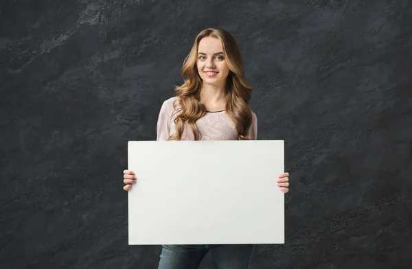 Joven mujer sonriente con papel blanco en blanco — Foto de Stock