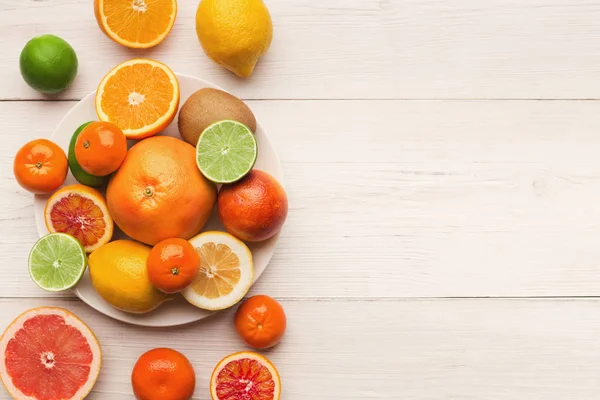 Platter de frutas cítricas sortidas em tábuas de madeira branca, vista superior — Fotografia de Stock